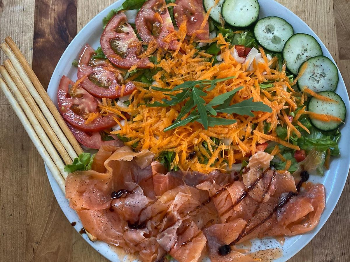 Plato de salmón ahumado con ensalada, tomate, zanahoria y pepino