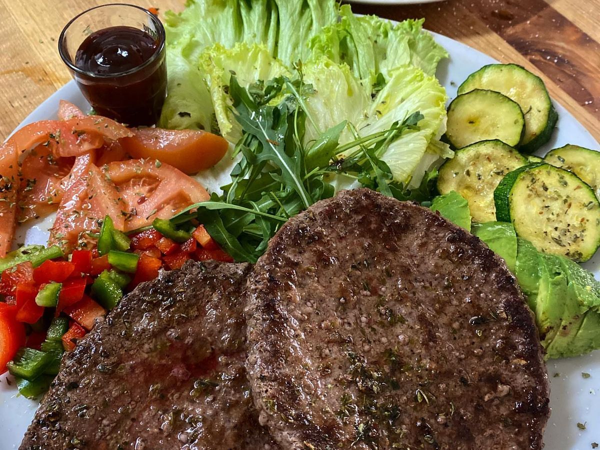 Plato de carne: dos hamburguesas a la plancha con verduras, aguacate y calabacín